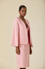Capa de mujer color rosa, con diseño de mangas abiertas tipo capa y silueta estructurada. Presenta un corte frontal abierto y una caída fluida y elegante.