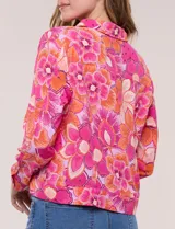 Camperita liviana de silueta entallada, con estampado floral en tonos azules, cuello camisero, cierre frontal con botones y bolsillos en el pecho.