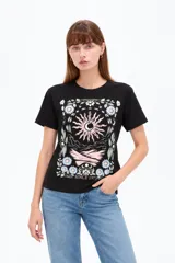 Remera negra de algodón, manga corta, con cuello redondo y diseño gráfico estampado en el pecho que incluye un sol, flores y la leyenda 'Since 1973'.