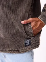 Sobrecamisa de pana color beige, con cierre frontal de botones a presión, dos bolsillos frontales con solapa y bolsillos laterales. Presenta cuello clásico y diseño acolchado con forro interior.