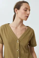 Remera verde oliva con escote en V, manga corta con dobladillo y cierre frontal con botones.