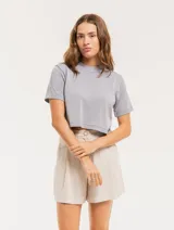 Short color beige de lino con tiro alto, elástico en la pretina trasera, cierre delantero con botón, tablas en el frente, bolsillos delanteros y dobladillo invisible.