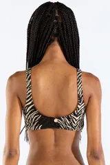 Top de bikini con estampado animal print tipo cebra en tonos negro y beige, escote en V y detalle de hebilla metálica rectangular en el centro.