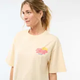 Remera de corte oversize color amarillo claro, con estampa gráfica en la espalda que representa una lata de sardinas con limón sobre un fondo de cuadrillé rojo.