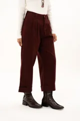 Pantalón de corte recto y tiro alto en color bordó, con diseño de pinzas en la cintura, bolsillos laterales y ruedo con dobladillo ancho.