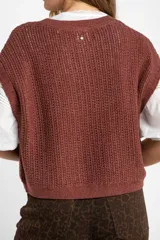 Chaleco sin mangas de tejido de punto color rosado pálido, con textura calada y acabado lurex, corte al cuerpo y cuello redondo.