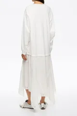 Vestido midi de corte holgado con diseño bimaterial. La parte superior simula una remera de manga larga en color negro, mientras que la falda presenta un estampado animal print en tonos marrones con bajo irregular y fluido.