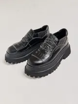 Mocasines color marrón con estampado de cocodrilo y plataforma negra con suela dentada.