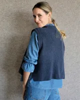 Chaleco de punto en lana lambswool, con cuello redondo y diseño acanalado. Presenta aberturas laterales y cierre con botones en los costados.