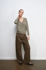 Chaqueta tipo cárdigan de lana, color beige, con escote en pico, manga larga y cierre frontal con botones.