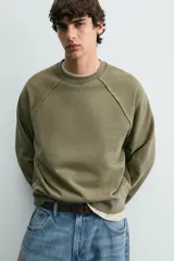 Sudadera relaxed fit color verde militar con efecto lavado, cuello redondo y manga larga. Confeccionada en tejido de algodón con interior afelpado y acabados en rib.
