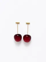 Caravanas colgantes con diseño de cerezas, compuestas por un palito metálico dorado y una esfera de resina color rojo intenso.