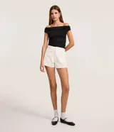 Short tipo mom de cintura alta en sarga blanca, con trabillas, bolsillos y aplicaciones de brillos sutiles.