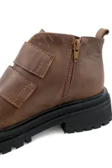 Botas marrones de cuero con suela track negra y ajuste con dos tiras de velcro.