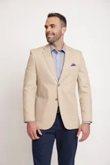 Blazer color beige, de corte slim fit, con solapa clásica, dos botones y bolsillos delanteros con solapa.