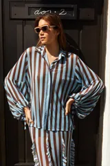 Camisa de tul elastizado con cuello solapa y abotonada, de mangas largas abullonadas con tiras para atar.