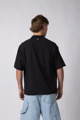 Camisa de hombre de manga corta color beige claro, confeccionada en lino. Tiene cuello clásico, cierre frontal con botones y corte recto.