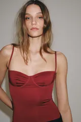 Body lencero color bordó de poliamida, con escote corazón con aro, tirantes finos regulables y cierre inferior a presión.