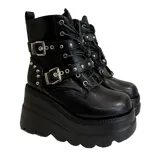 Botas negras de caña media con plataforma de goma, cordones y hebillas ajustables.