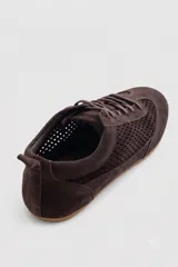 Championes de gamuza color tostado con diseño de paneles perforados en los laterales y empeine. Presentan cierre con cordones al tono y tirador en el talón.