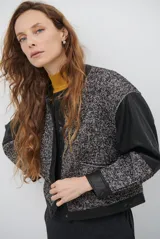 Chaqueta de diseño combinado con paneles de tejido de espiga en tonos marrones y burdeos, y paneles de cuero marrón en mangas y bordes. Presenta cuello redondo, cierre frontal con botones metálicos a presión y bolsillos delanteros.
