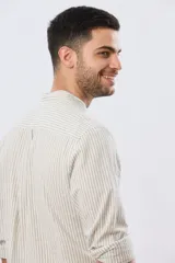 Camisa de lino a rayas verticales blancas y azules, de manga larga, con cuello mao y cierre frontal de botones.