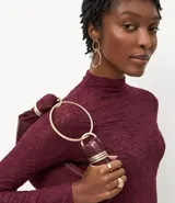 Blusa de encaje negro con cuello alto y mangas largas, de corte ajustado y diseño con transparencias.