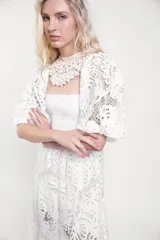 Vestido largo de encaje blanco con cuerpo fruncido elastizado, mangas cortas abullonadas y falda con vuelo.