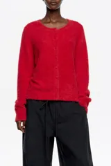 Sweater de punto de textura suave y afelpada, color rojo, con escote redondo y cierre frontal de botones al tono.