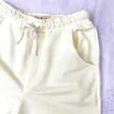 Short deportivo amarillo claro con cintura elástica ajustable con cordón y bolsillos laterales.