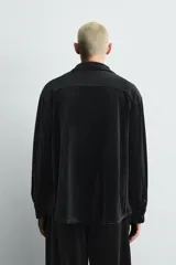 Sobrecamisa de corte relajado confeccionada en tejido de terciopelo elástico, con cuello solapa, manga larga con puños abotonados y cierre frontal de botones.
