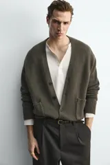 Cárdigan de punto con mezcla de lana y cashmere, de corte relajado, cuello en pico y cierre frontal con botones. Presenta mangas largas con puños acanalados y dos bolsillos de plastrón en la parte frontal.