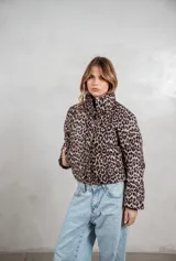 Campera puffer corta con estampado animal print, cuello alto y cierre frontal. Cuenta con bolsillos laterales y diseño acolchado.