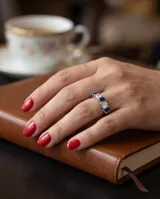 Anillo de plata 925 con diseño de medio sin fin, engastado con cinco piedras de circonia alternadas entre blancas y azul zafiro.