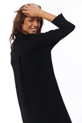 Vestido midi negro con corte camisero, abotonado al frente y con mangas 3/4. Tiene cuello clásico y bolsillos laterales.