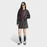 Campera Adidas estilo bomber de efecto piel color negro, de corte holgado, con cierre frontal de cremallera y diseño urbano.