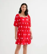 Vestido corto rojo con estampado de lunares rosas, escote cuadrado, mangas cortas abullonadas y volado en el ruedo.