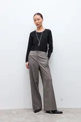 Pantalón sastrero de corte recto y tiro alto, confeccionado en tela con textura melange en tono beige. Presenta cierre frontal con botón y bolsillos laterales.