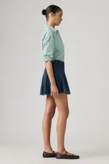 Minifalda de denim azul oscuro con diseño de godets que crean un efecto plisado y acampanado. Presenta costuras visibles y un corte estructurado.