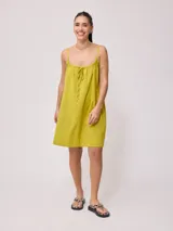 Vestido corto color amarillo verdoso, de corte suelto y breteles finos.
