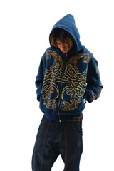 Hoodie azul con cierre y bolsillos laterales, con estampado dorado de hojas de acanto en el frente y las mangas.