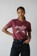 Remera de algodón color bordó con cuello redondo y mangas cortas. Presenta un estampado frontal con forma de estrella y la frase 'DISCO DREAM' con detalles en strass.