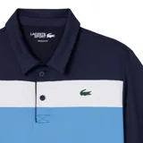 Chomba Lacoste deportiva de manga corta, color azul marino con franjas horizontales en el pecho en blanco, celeste y verde claro. Cuenta con cuello polo, cierre de botones y el clásico logo del cocodrilo bordado en el pecho.