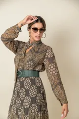 Cinto de cuero color beige con elástico y hebilla ovalada metálica plateada.