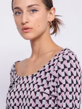 Top de tejido de punto con estampado geométrico en blanco y negro, de manga larga y cuello redondo.