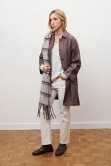 Spolverino largo de jean color azul, con cuello camisero, botones frontales y costuras decorativas en blanco.