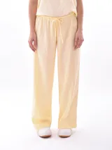 Pantalón ancho de tiro alto, color negro, con cintura elástica y cordón ajustable.