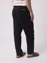 Pantalón negro de corte recto con cintura elástica tipo jogger y bolsillos laterales, confeccionado en mezcla de algodón y elastano.