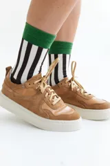 Zapatillas de gamuza verde oliva con cordones marrones y suela de goma color crema.