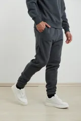 Pantalón jogging de corte ajustado, con cintura elástica y puños elastizados en los tobillos. Presenta un diseño minimalista en color gris oscuro, ideal para un look urbano y deportivo.